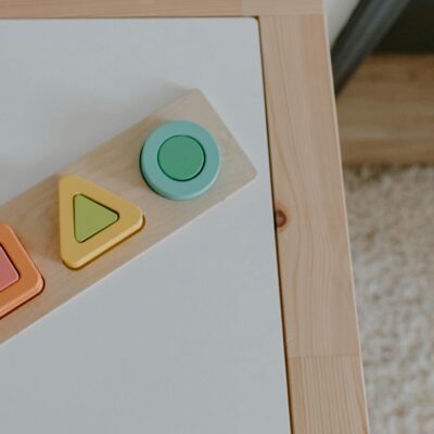Simple wooden geometric toys on a textured table, ideal for child education imagery.