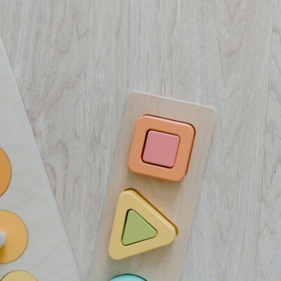 Top view of a wooden kids toy puzzle with colorful geometric shapes for educational play.