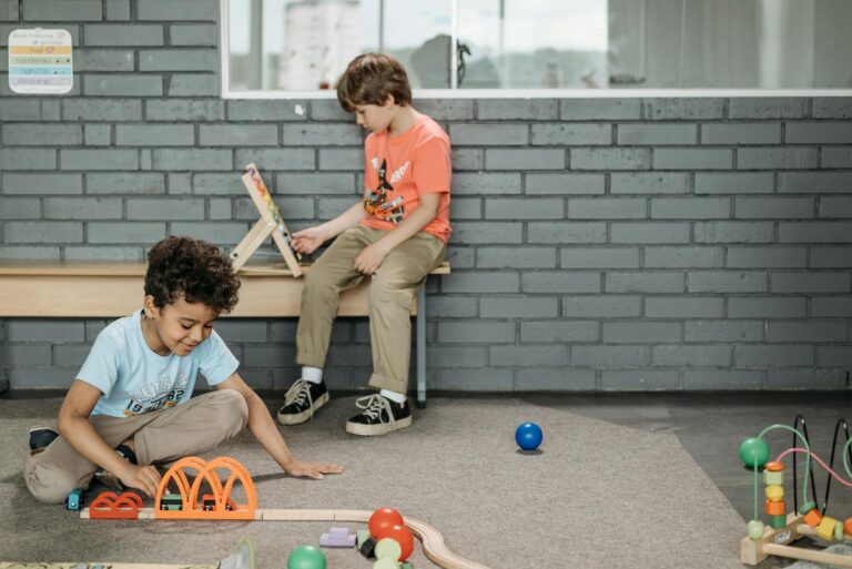 Two boys engaged with educational toys in a kindergarten classroom setting.
